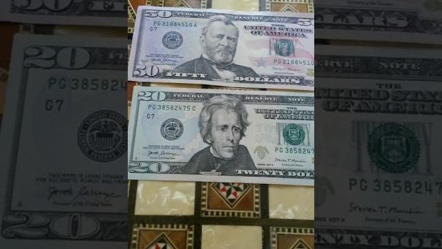 1 БАНКНОТА 50 И 1 БАНКНОТА 20 ДОЛЛАРОВ лежат номером серии на крутой шахматн. доске Третьего Августа 1 БАНКНОТА 50 И 1 БАНКНОТА 20 ДОЛЛАРОВ лежат номером серии на крутой шахматн. доске Третьего Августа